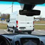 Ford Transit Custom parkt rückwärts in eine Parklücke ein, unterstützt durch die Rückfahrkamera