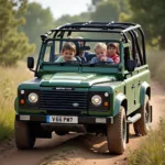 Land Rover Defender 7 Sitzer fährt mit Familie im Gelände