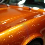 Orange Metallic Autolackierung: Ein Blick auf die schimmernde Oberfläche eines Fahrzeugs in Orange Metallic.